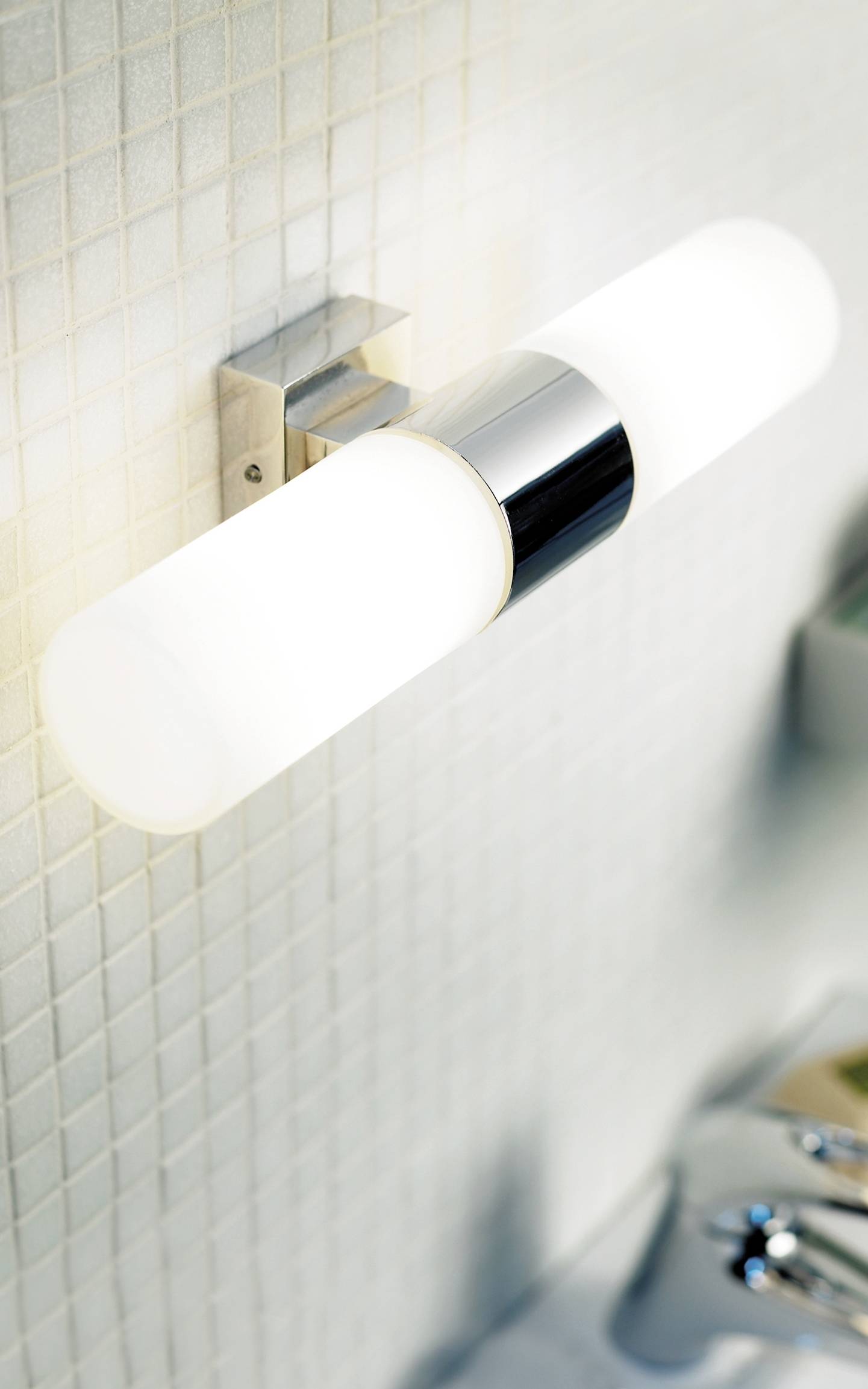 Wandleuchte mit modernem, schlankem Design, montiert auf beige Kacheln, beleuchtet einen Bereich in einem stilvoll eingerichteten Raum.