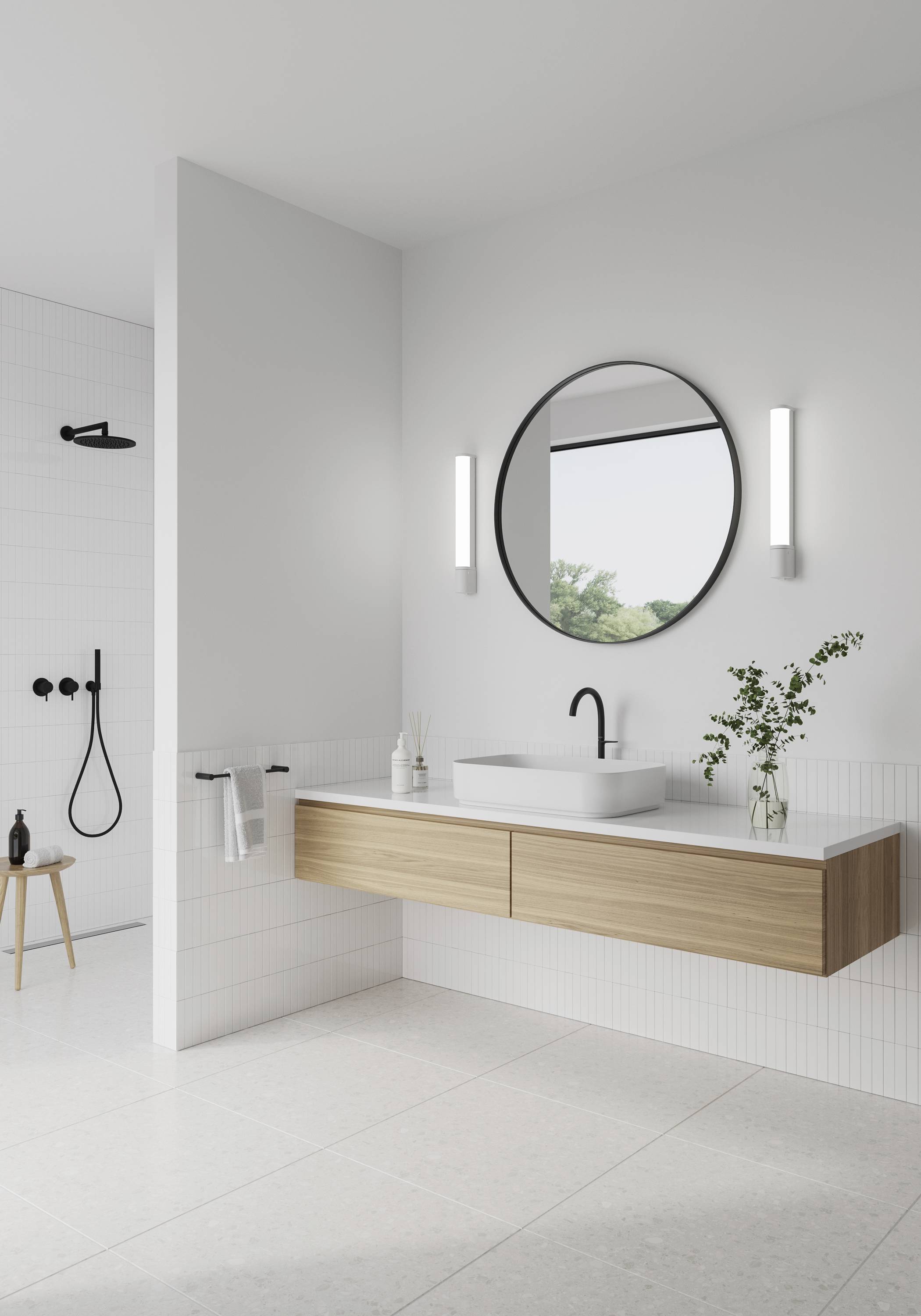 Modernes Badezimmer mit rundem Spiegel, Holz-Waschtisch und freistehendem Waschbecken. Zwei Wandleuchten flankieren den Spiegel.