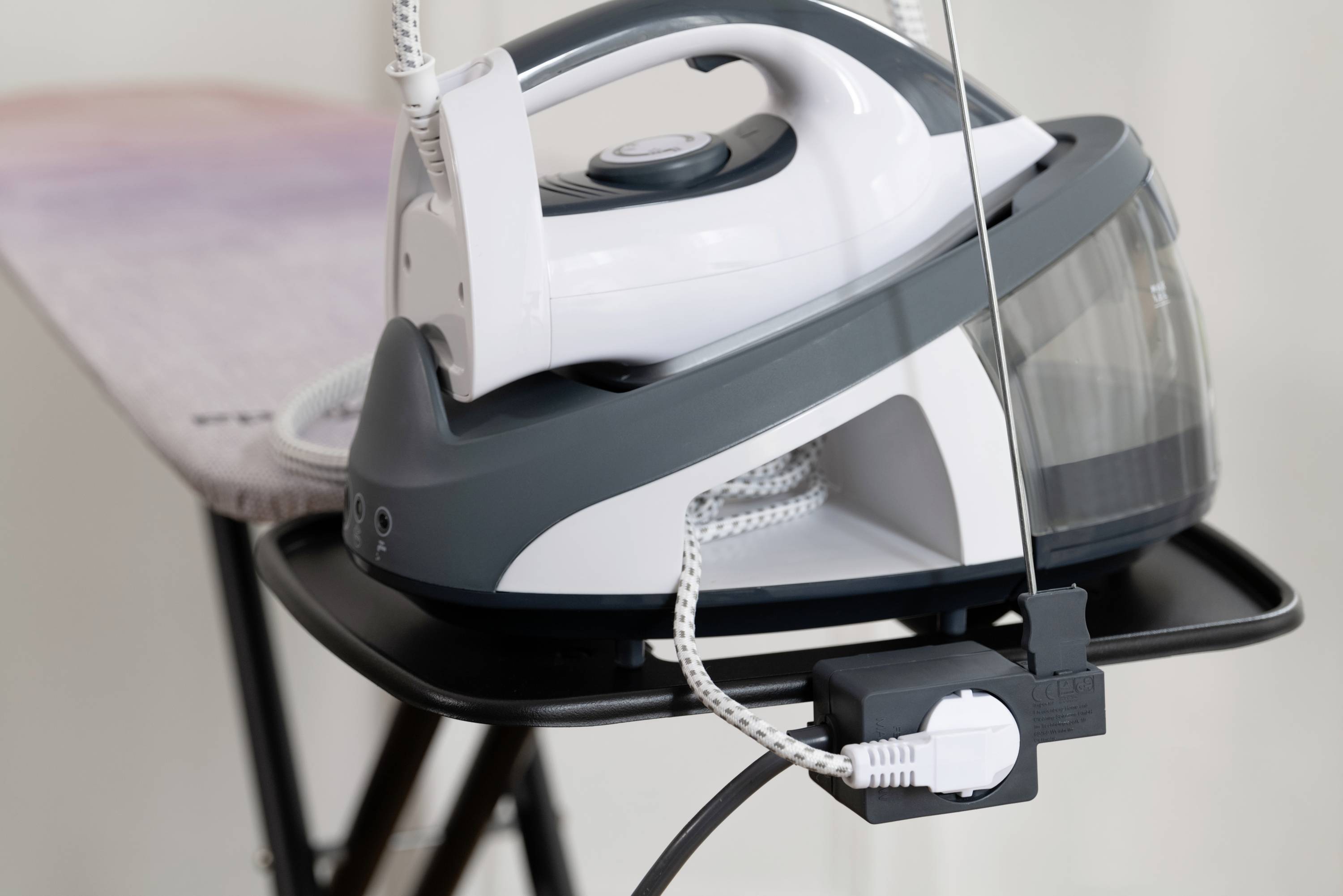 Dampfbügelstation auf einem Bügelbrett, bereit zum Einsatz. Hauptmerkmal ist der Wasserbehälter für kontinuierlichen Dampfausstoß.