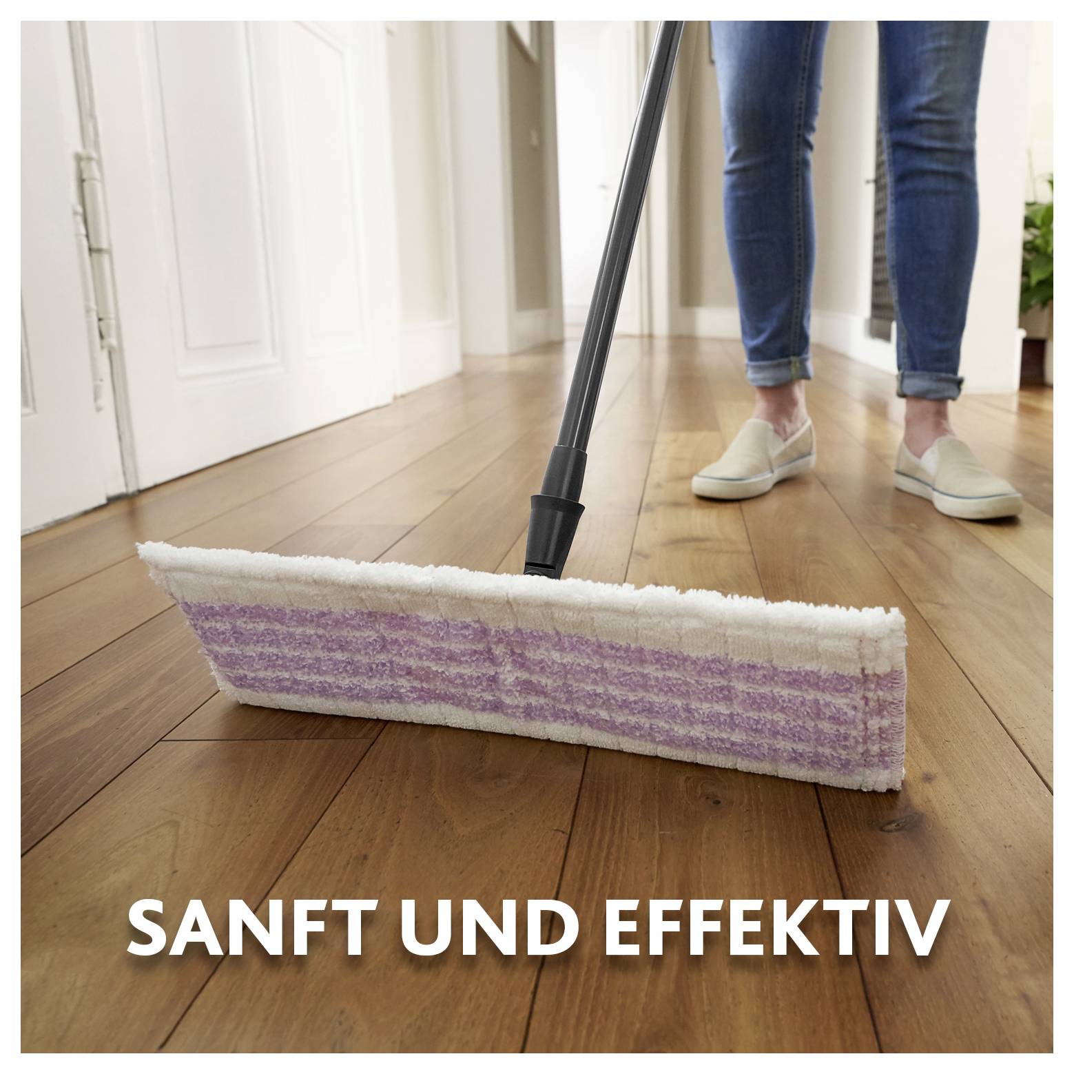 Mopp mit violett-weißem Tuch auf einem Holzboden neben einer Person in Jeans und Hausschuhen; der Text sagt „SANFT UND EFFEKTIV".