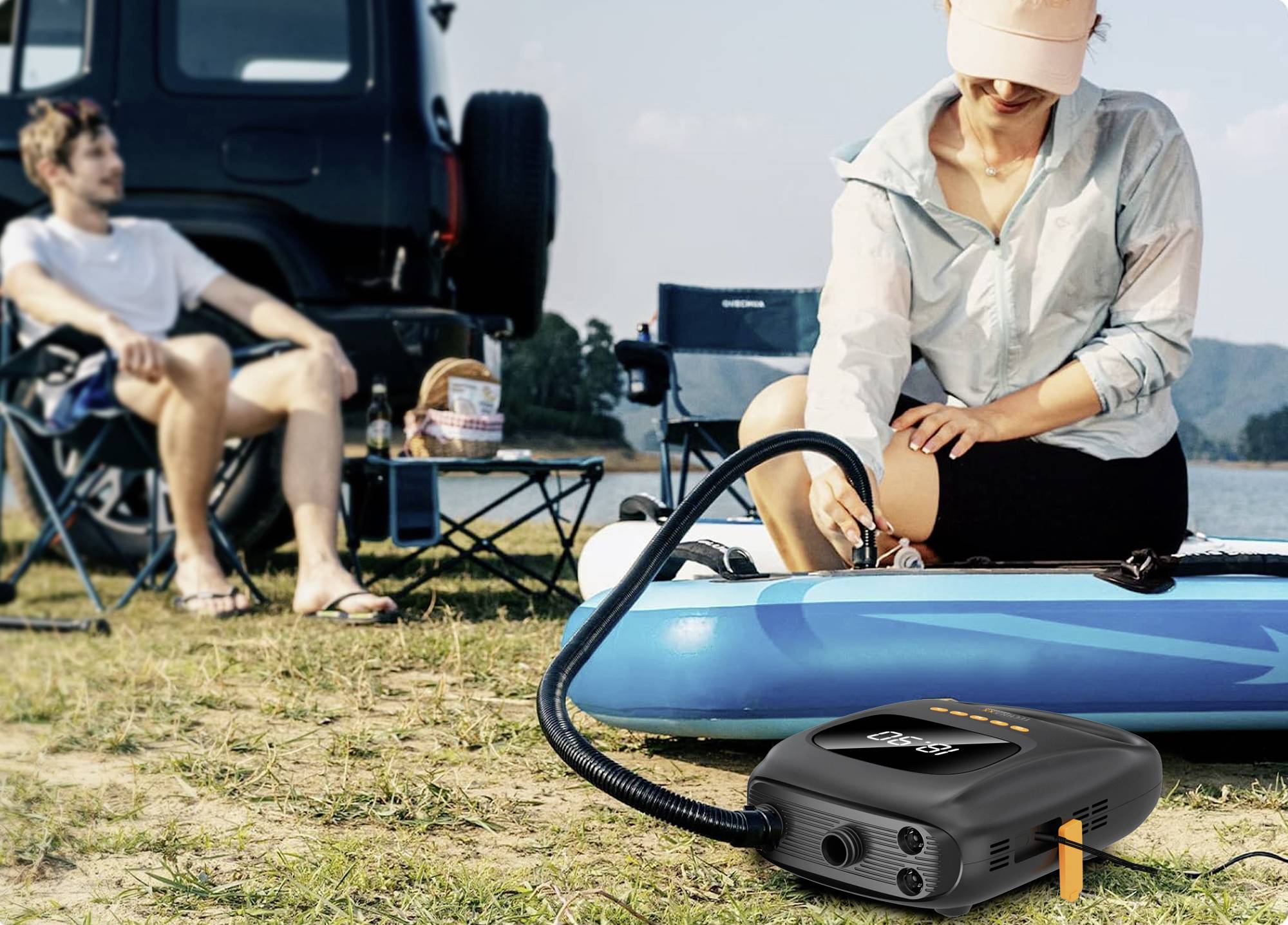 Eine Person pumpt ein Kajak auf einem Campingplatz am See auf, während eine andere Person auf einem Klappstuhl sitzt.