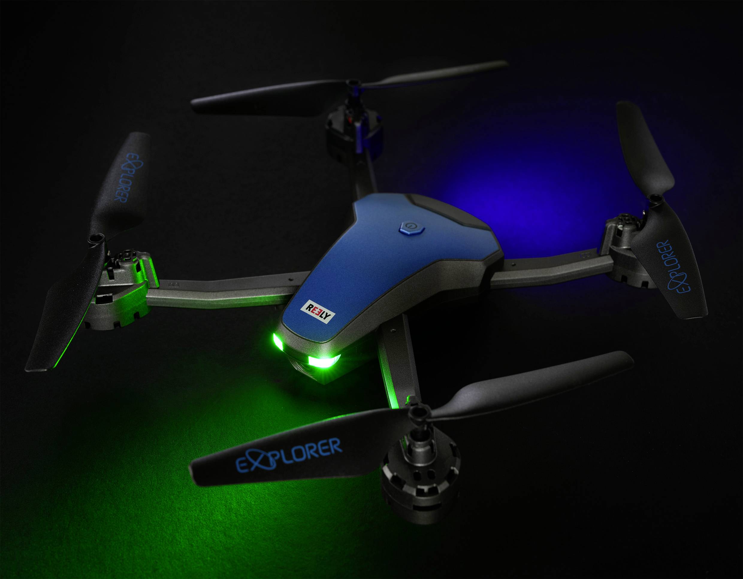 Das Bild zeigt einen Einsteiger-Quadrocopter bei dem die nach vorne ausgerichteten LEDs grün leuchten. Nach hinten gibt der Quadrocopter blaues Licht ab.