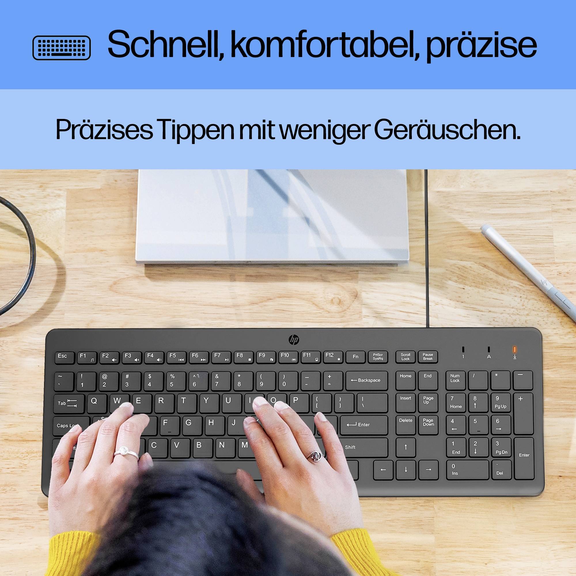 Tastatur auf Holzschreibtisch mit Händen beim Tippen. Text: 'Schnell, komfortabel, präzise. Präzises Tippen mit weniger Geräuschen.'