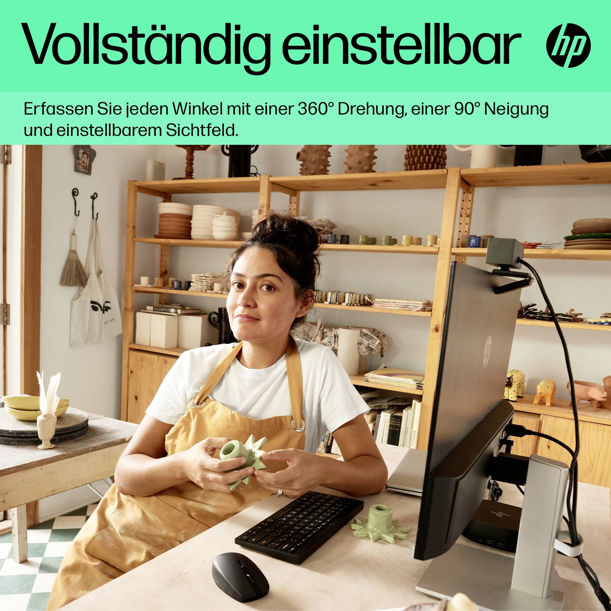 Eine Frau in einer Werkstatt sitzt vor einem Computer mit einem handgefertigten Objekt. Text: 'Vollständig einstellbar'.