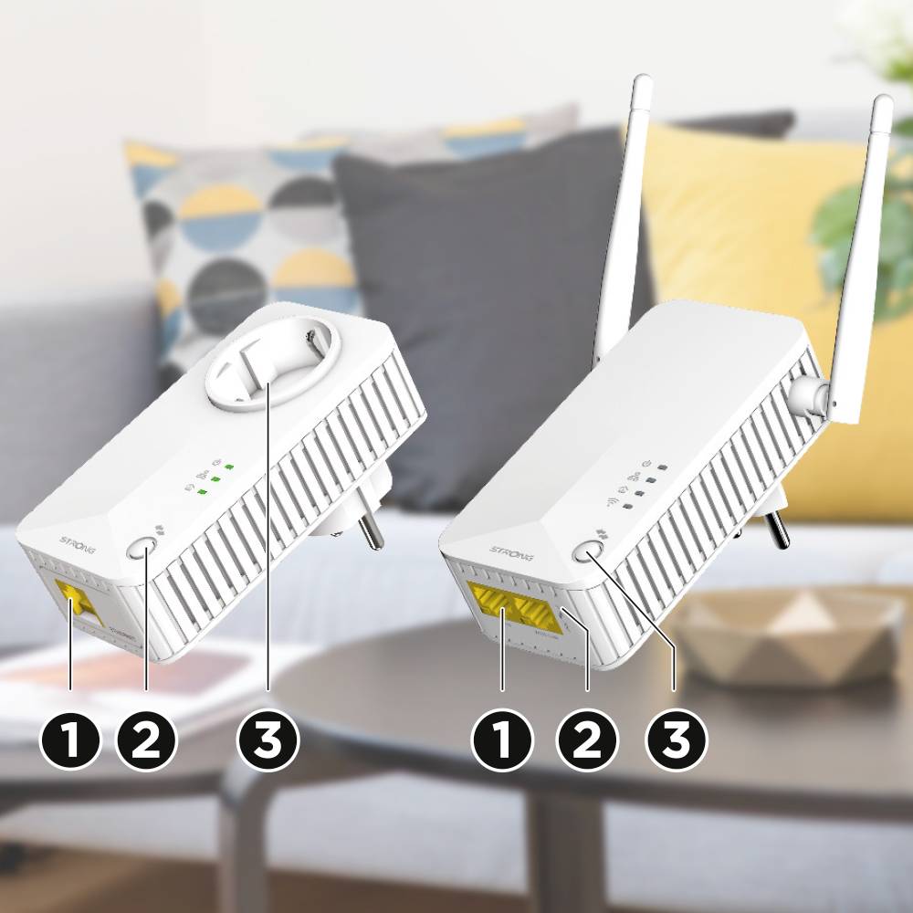 Zwei WLAN-Repeater auf einem Tisch mit Antennen und Status-LEDs. Im Hintergrund ist ein Sofa mit gemusterten Kissen zu sehen.