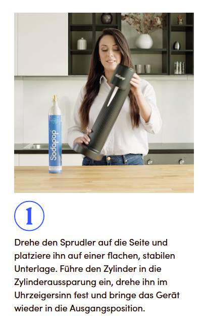 Eine Person platziert einen Zylinder in einen Wassersprudler. Daneben steht eine Gasflasche. Anweisung: 'Drehe den Sprudler auf die Seite und platziere ihn stabil.'