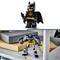 Kleine Batman-Actionfigur aus LEGO und größere Batman-Roboterfigur, beide auf einem Regal platziert.