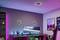 Moderne Arbeitszimmer mit beleuchtetem Schreibtisch und großem Curved-Monitor, futuristische Deko und bunte Lichteffekte an Wand und Decke.