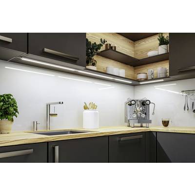 Moderne Küche mit Holztresen, Edelstahlspüle und Kaffeemaschine. Pflanze und Küchenutensilien auf der Arbeitsfläche.