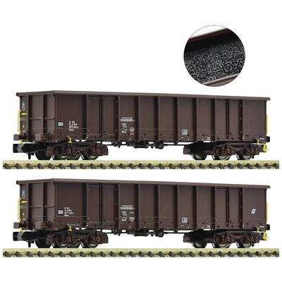 Zwei braune Güterwaggons auf Gleisen, gefüllt mit schwarzem Schüttgut, möglicherweise Kohle oder Kies, Detailbild zeigt Material.
