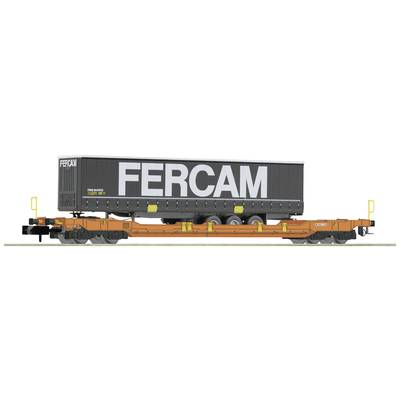 Ein Güterzug mit einem großen, rechteckigen 'FERCAM'-Container beladen, auf einem flachen, orangefarbenen Waggon platziert.