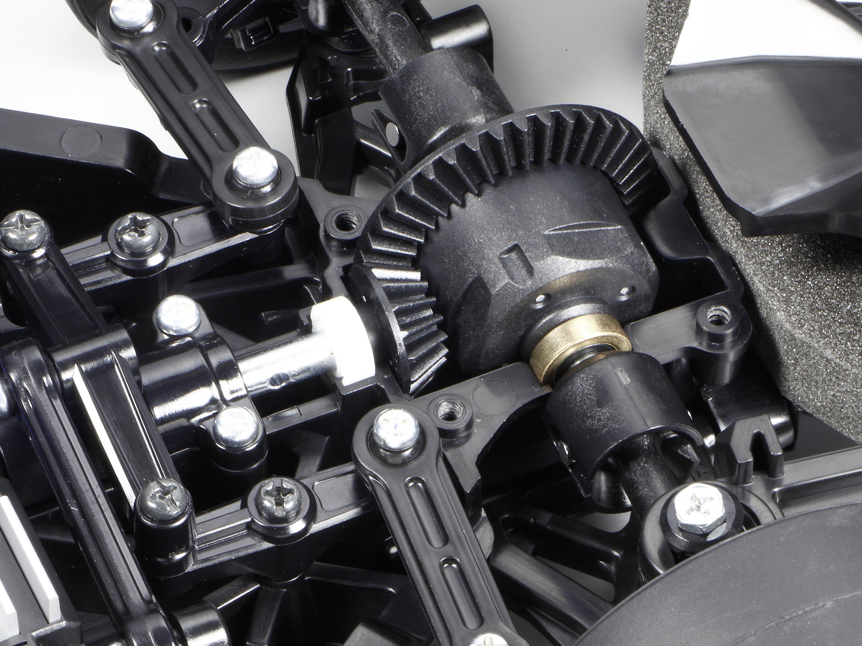 Nahaufnahme eines mechanischen Bauteils mit Zahnrädern und Schrauben, möglicherweise Teil eines Modellfahrzeugs oder technischen Geräts.