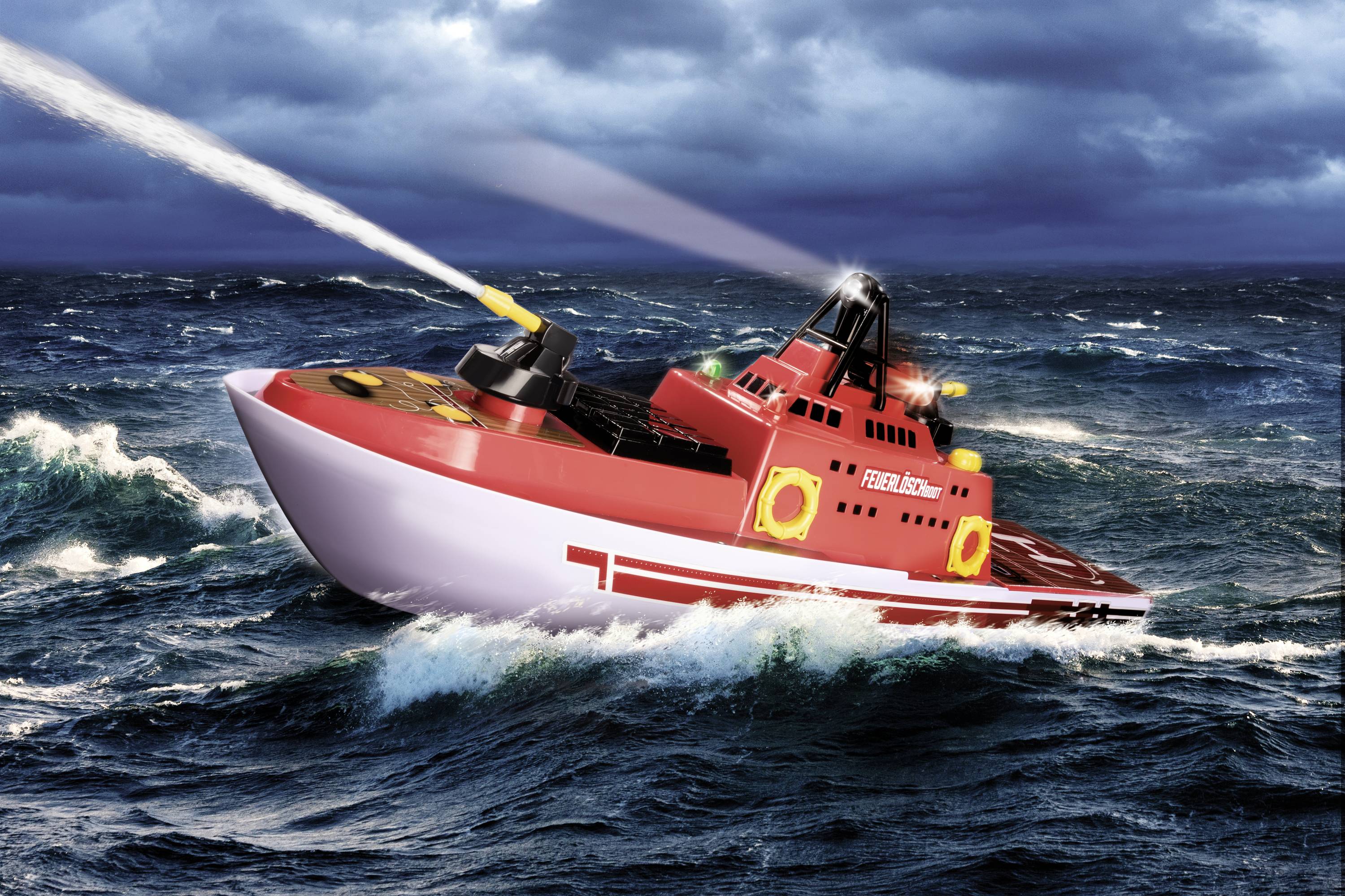 Ein rotes Feuerwehrboot spritzt Wasser auf stürmischer See. Wellen schlagen gegen den Rumpf, während sich das Boot durch das Wasser bewegt.