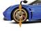 Blaues Auto mit goldenen Felgen und aerodynamischem Design, Vorderansicht. Räder sind hervorgehoben, um Autosport zu betonen.