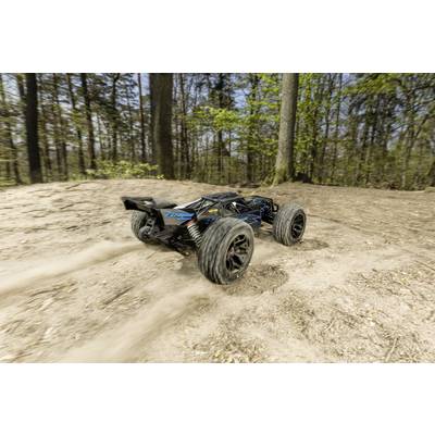 'Ferngesteuertes Auto fährt schnell auf einem Waldweg, hebt Staub auf. Bäume im Hintergrund. Bewegung und Geschwindigkeit werden dargestellt.'