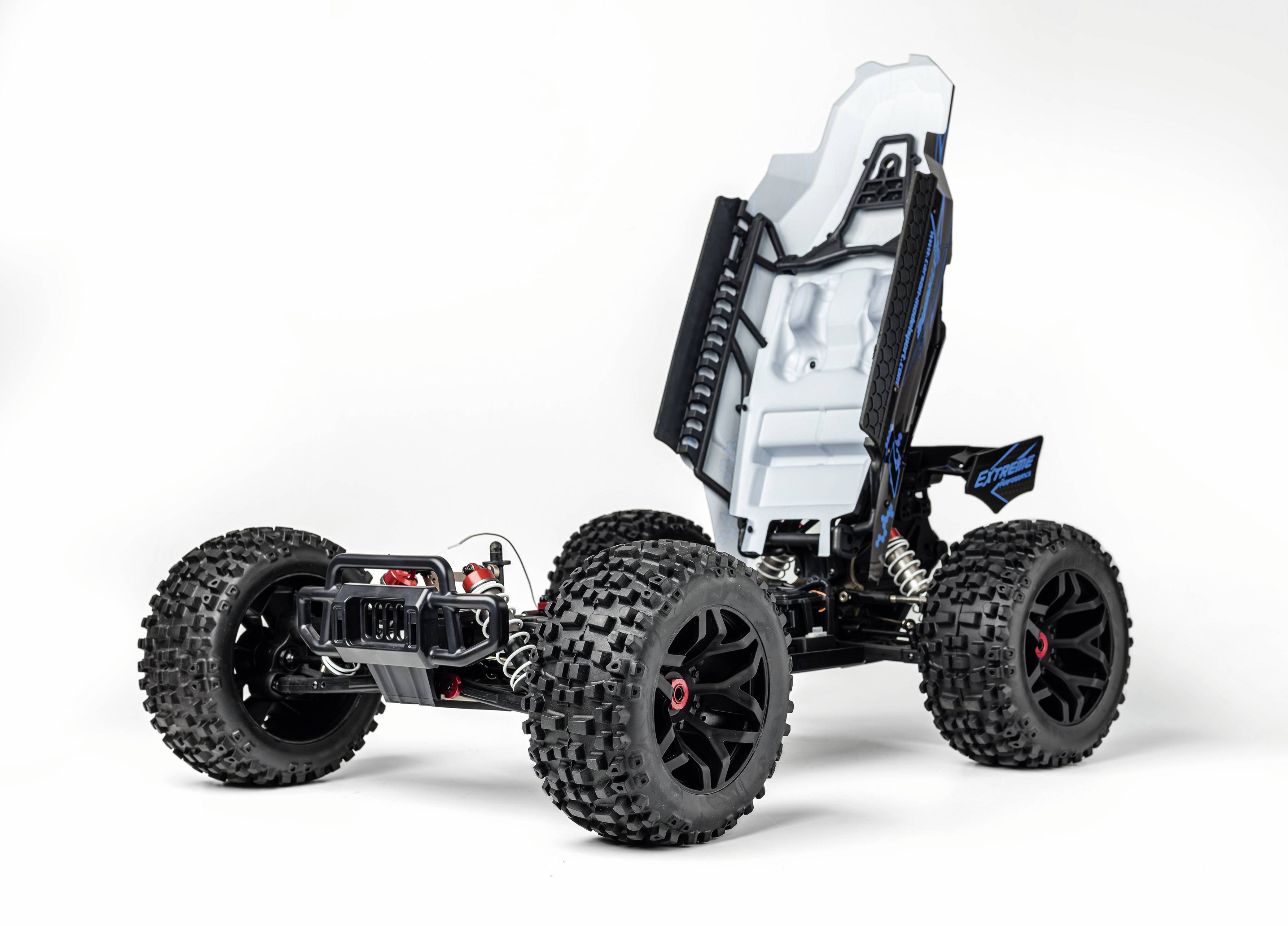Ferngesteuertes Modellauto-Chassis mit großen Offroad-Reifen und einem angedeuteten Fahrersitz in weiß. Keine Karosserie oder Motorhaube sichtbar.