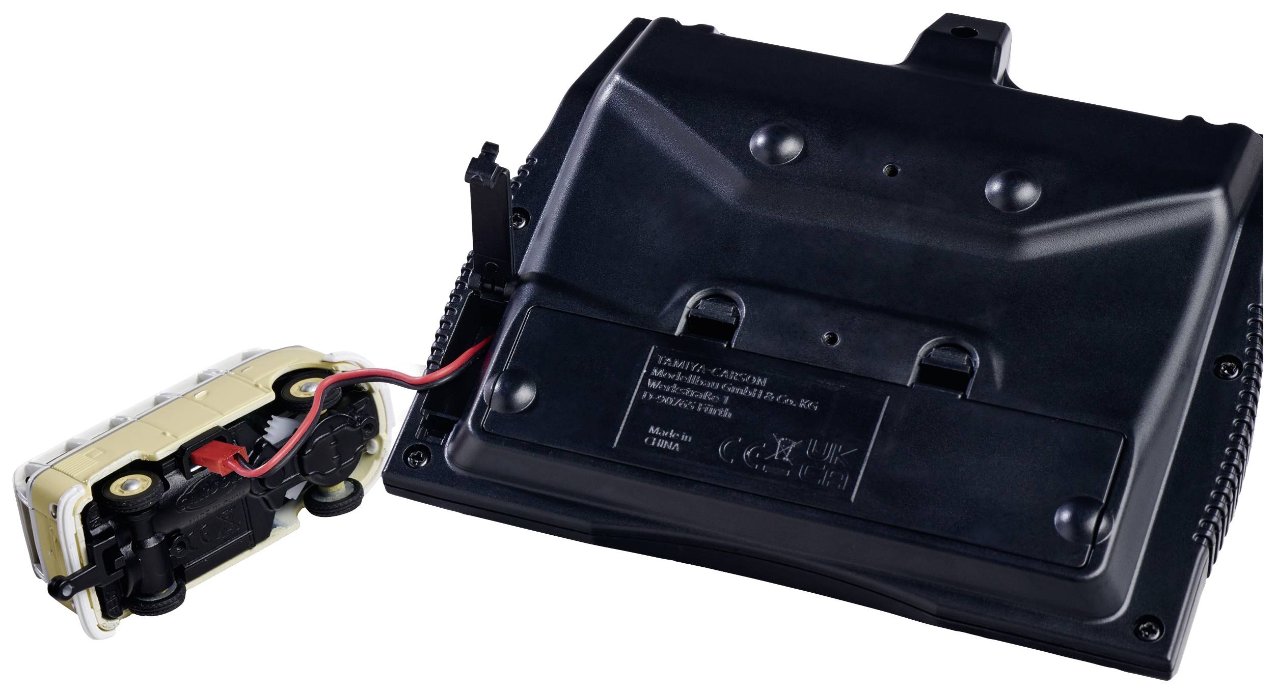 Das Bild zeigt eine schwarze elektronische Geräteeinheit mit Anschlusskabel, daneben ein gelbes Ladegerät mit rotem und schwarzem Kabel.