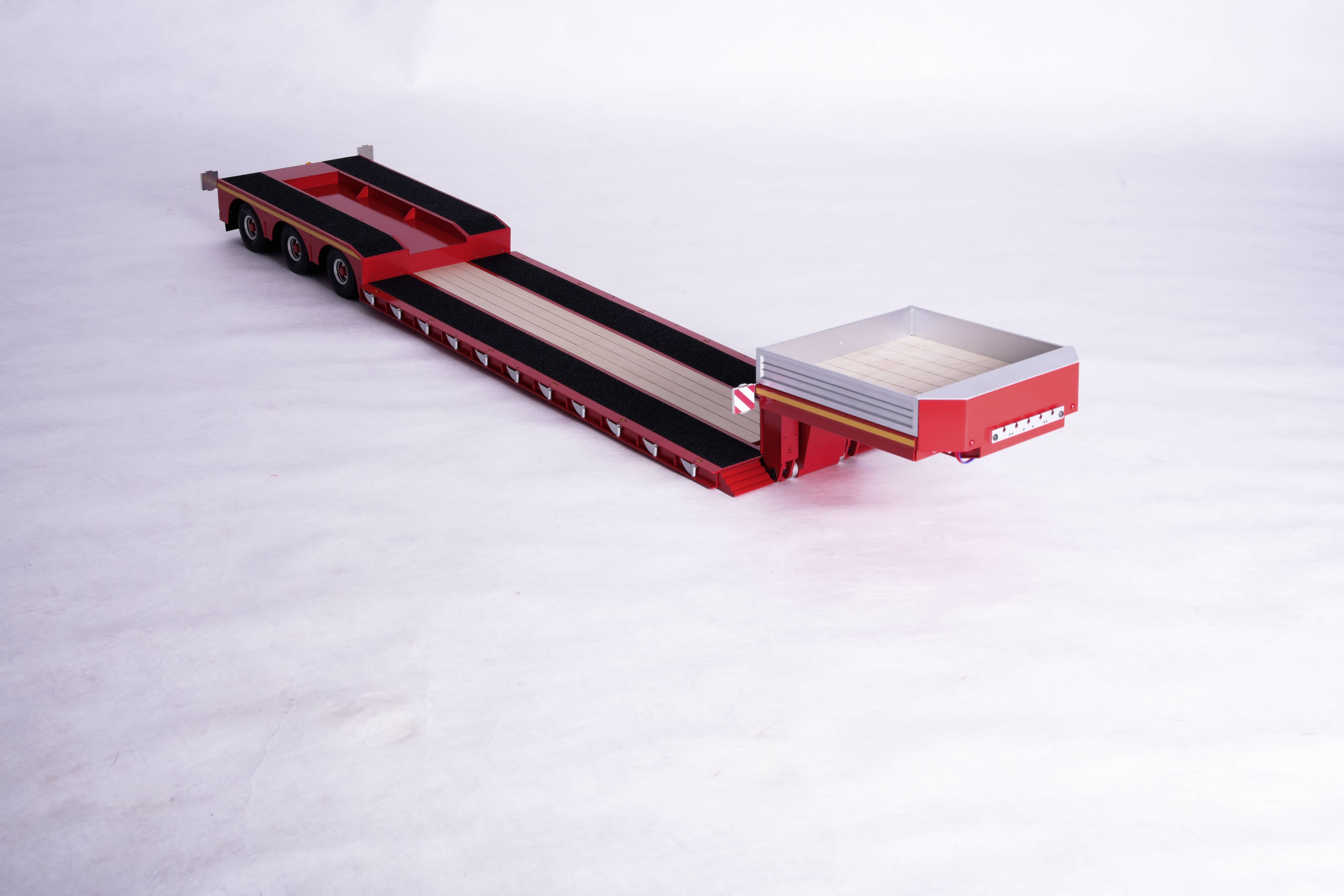 Ein roter Schwertransportanhänger auf einer weißen Fläche. Der Anhänger hat eine flache Ladefläche und mehrere Achsen für den Transport großer Lasten.