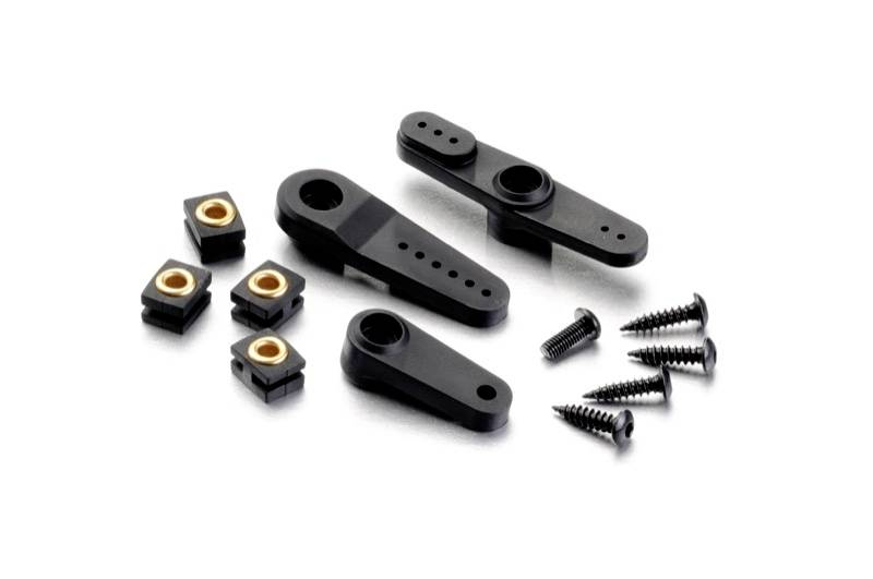 Plastikteile und Schrauben eines Modellbau-Sets, bestehend aus drei schwarzen Kunststoff-Armen und sechs kleinen quadratischen Muttern.