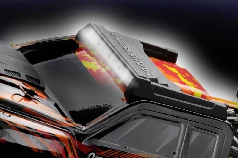 Nahaufnahme eines ferngesteuerten Autos in schwarz mit orange-gelbem Tarnmuster. Das Fahrzeug wirkt robust und dynamisch.