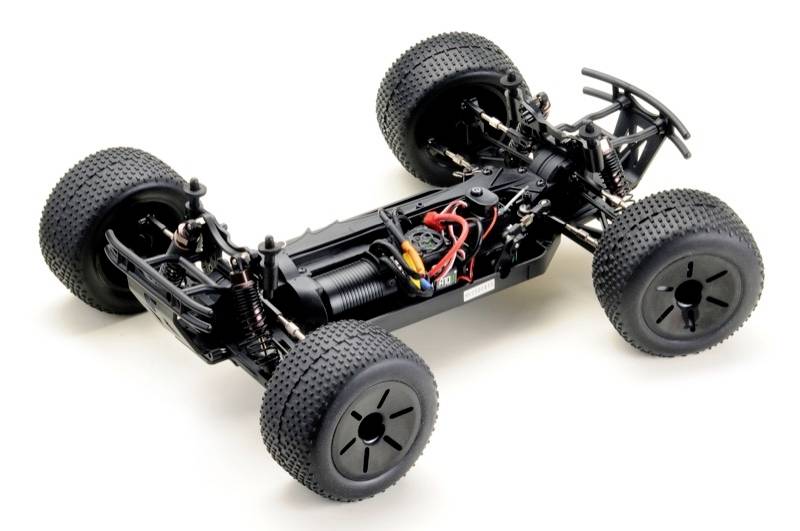 'RC-Auto-Chassis mit großen, profilierten Reifen, Federdämpfern und Motorverkabelung. Geeignet für unebenes Gelände.'