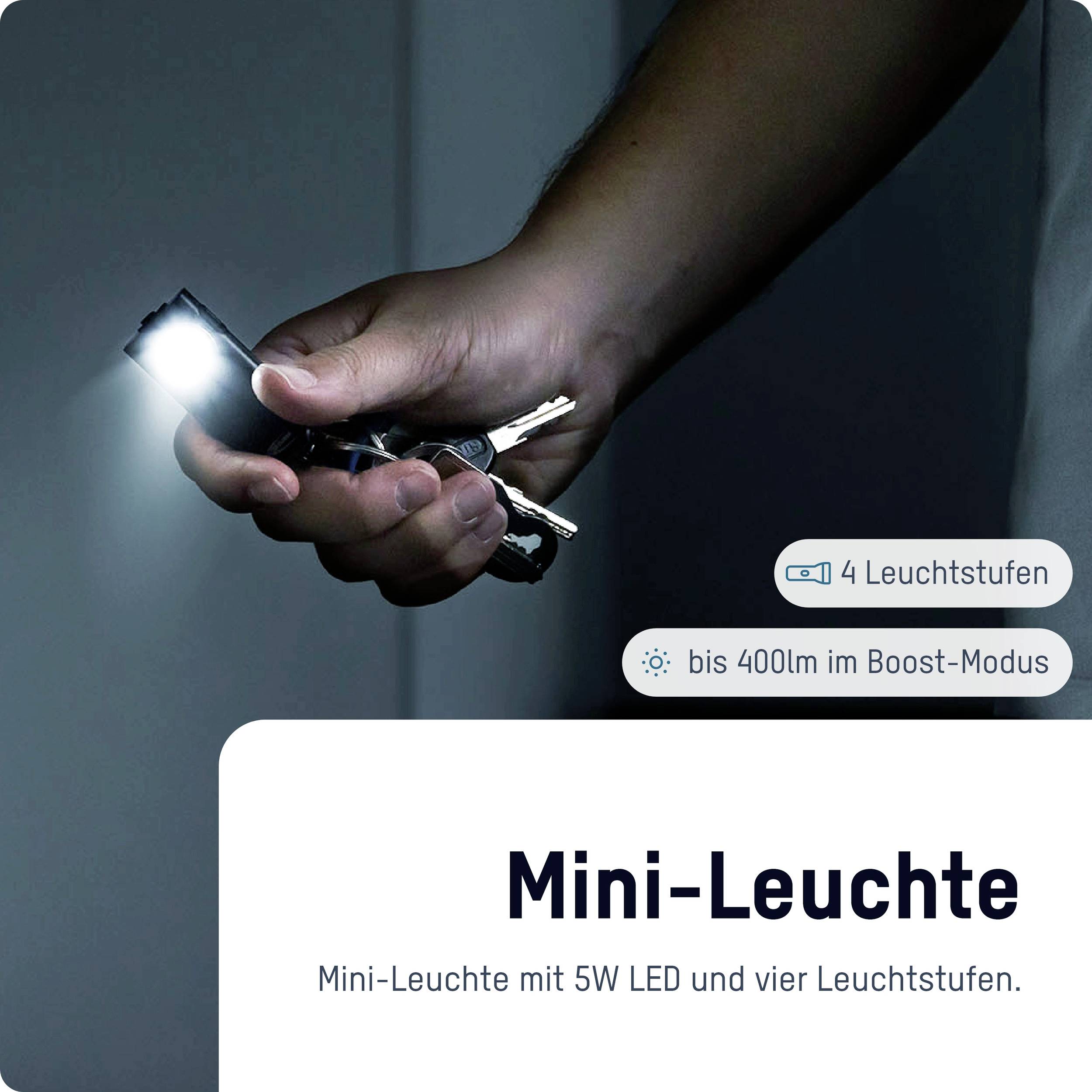 'Eine Hand hält eine Mini-Leuchte und Schlüssel. Text: Mini-Leuchte, 5W LED, bis zu 400lm im Boost-Modus, 4 Leuchtstufen.'