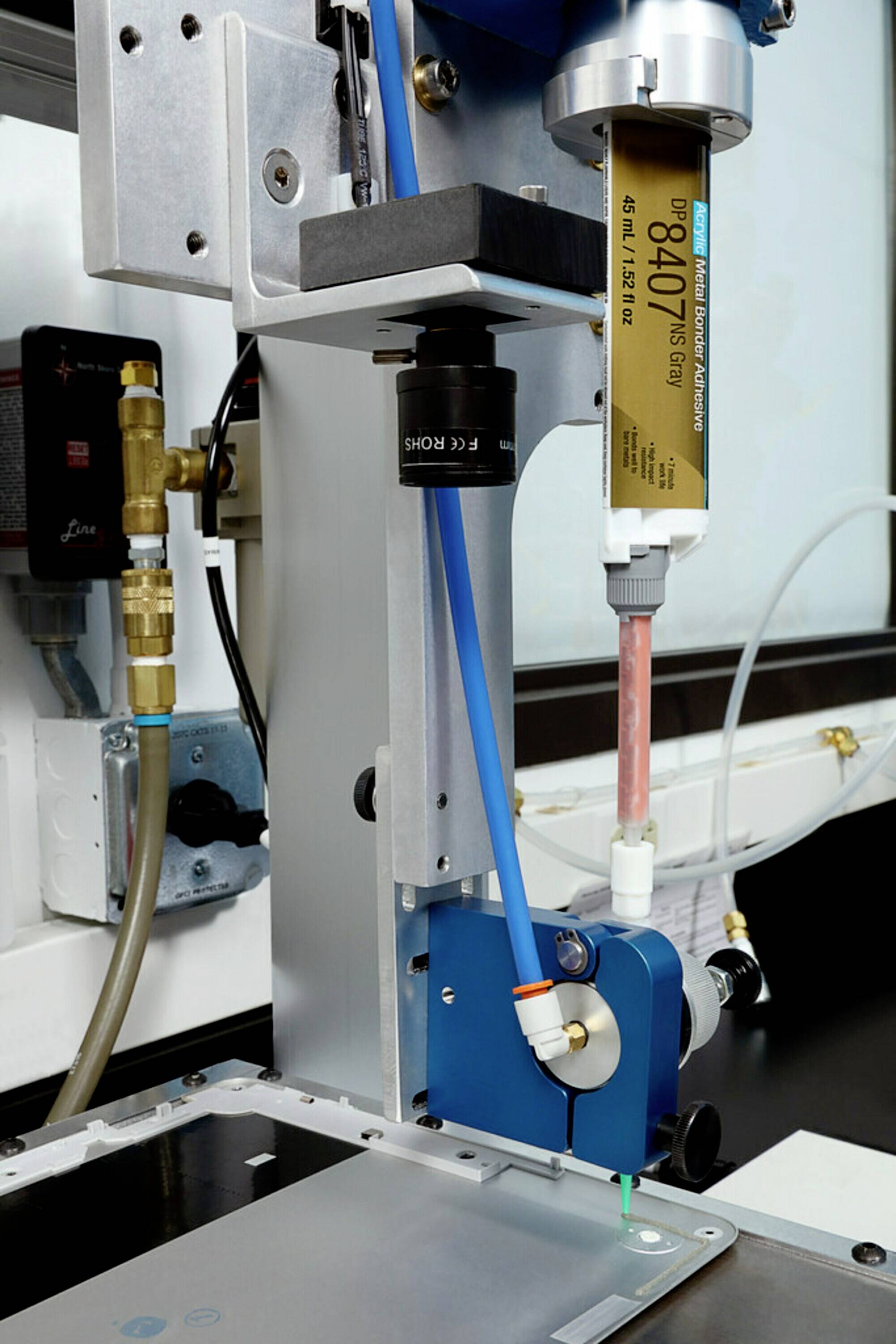 Maschine mit Kartusche, die für präzises Dosieren von flüssigem oder pastösem Material in industrieller Umgebung eingesetzt wird.