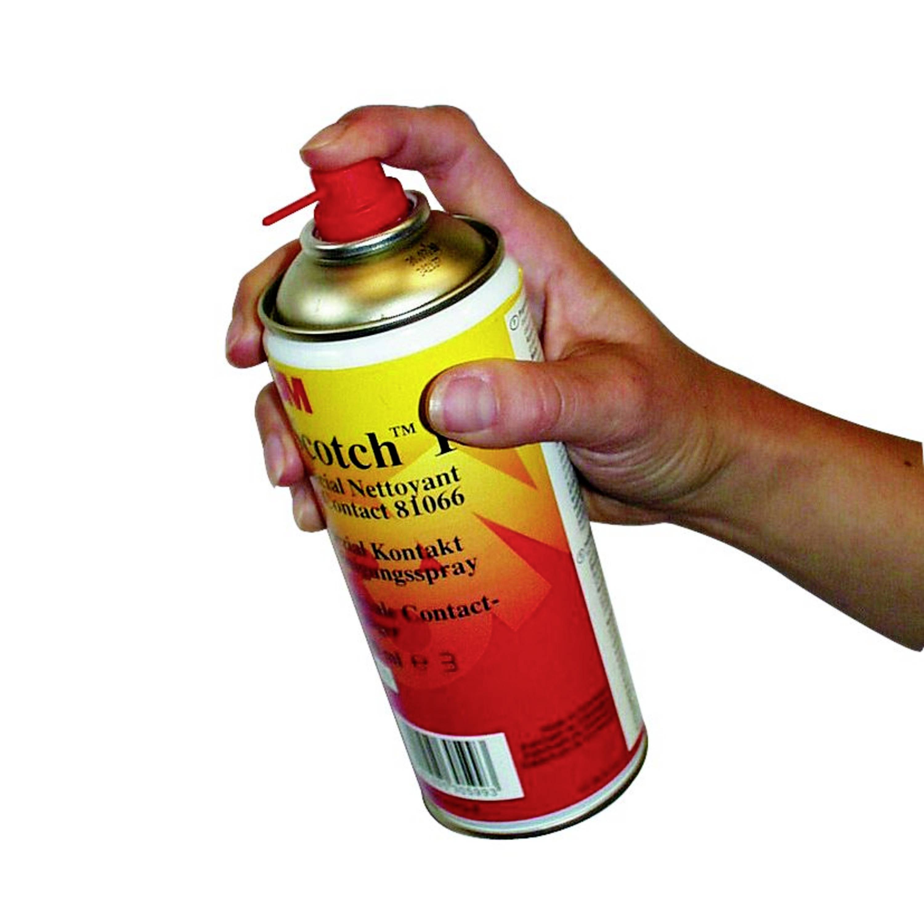 Hand hält eine gelbe Spraydose mit rotem Deckel, bereit zum Sprühen. Dose zeigt das Etikett und wirkt industriell.