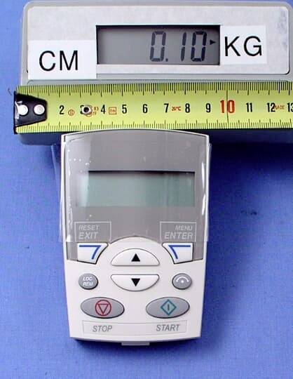 Ein elektronisches Messgerät zeigt '0.10 KG'. Ein Maßband liegt oben mit Markierungen bis 8 cm. Ein Tastenfeld ist sichtbar.