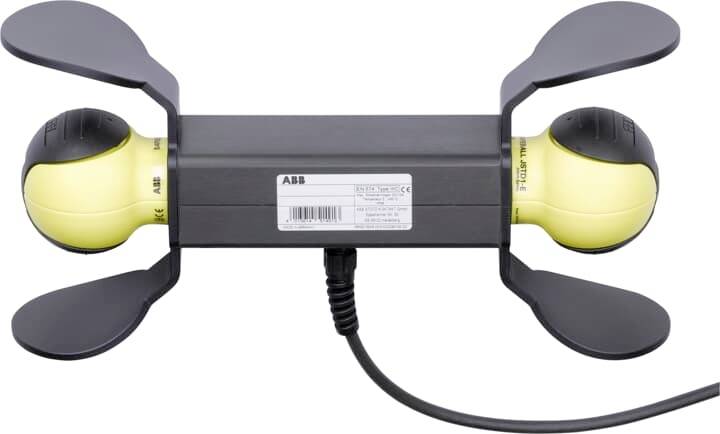 Ein rechteckiges Elektronikgerät mit zwei gelben Enden und vier flügelartigen schwarzen Platten. Ein Kabel ist mit dem Gerät verbunden.