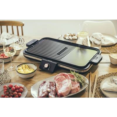 Elektrogrill auf einem gedeckten Tisch mit rohem Fleisch, Obst und Gläsern mit Weißwein. Vorbereitungen für ein gemeinsames Essen.