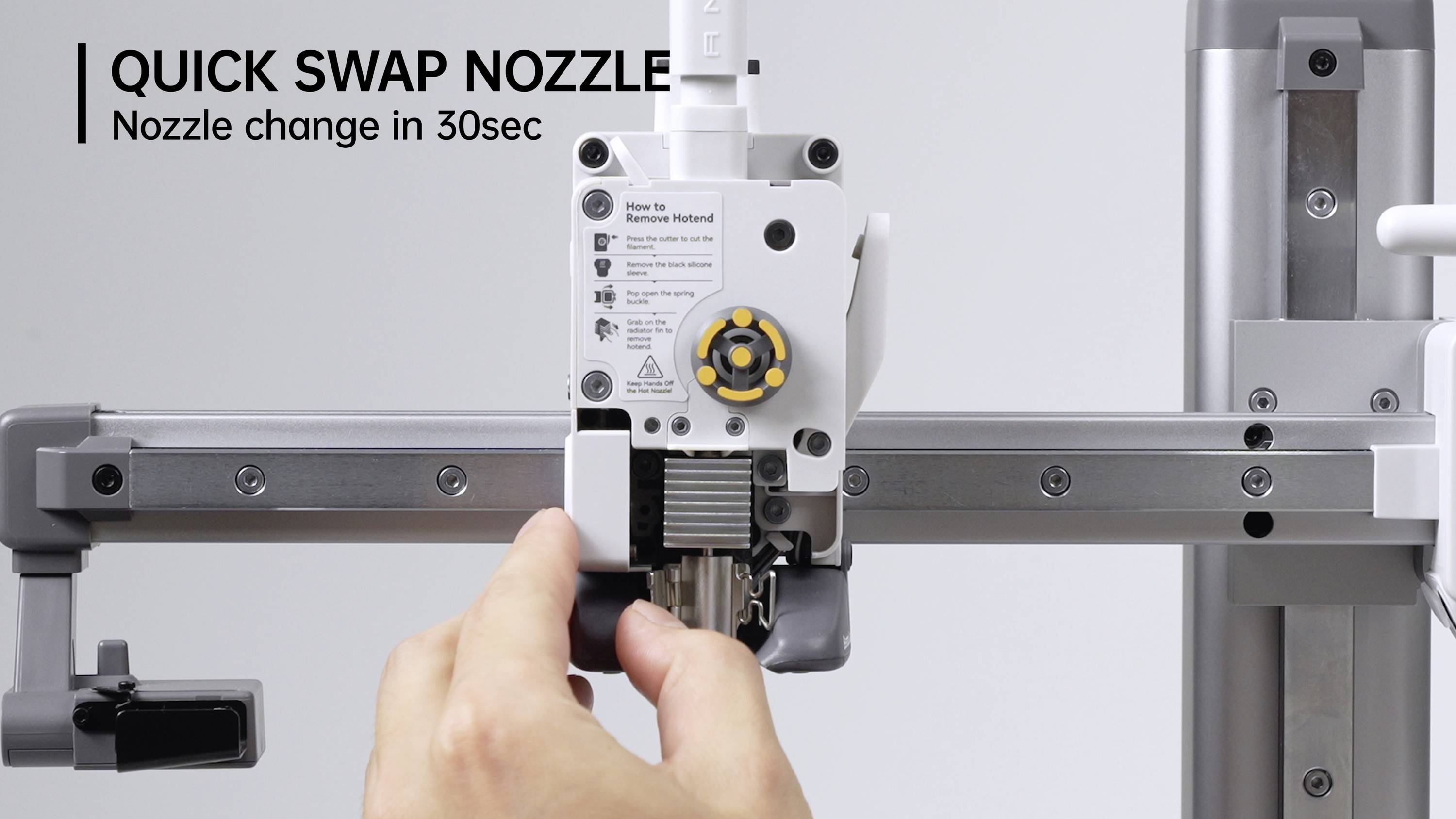 'Ein Hand wechselt die Düse einer Maschine. Text oben: QUICK SWAP NOZZLE - Nozzle change in 30Sec.'