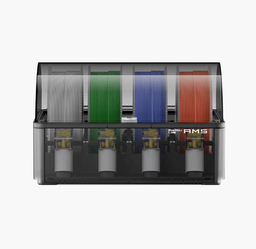 Ein Filament-Halter mit vier Rollen in Grau, Grün, Blau und Rot, geeignet für 3D-Drucker. Markenname 'AMS' sichtbar auf dem Gehäuse.