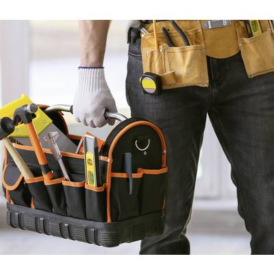Eine Person hält eine Werkzeugtasche mit Hämmern, Schraubendrehern und anderen Werkzeugen. Sie trägt einen Werkzeuggürtel.