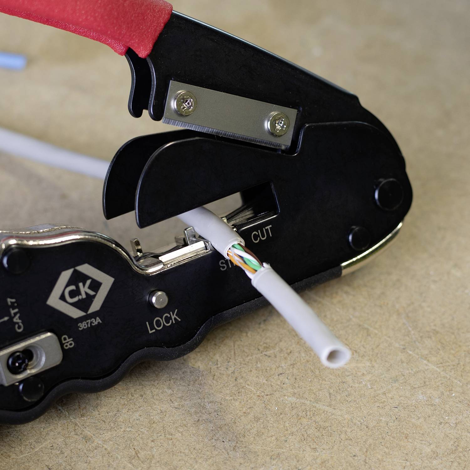 Ein Werkzeug schneidet ein Kabel, indem es die äußere Isolierung entfernt.