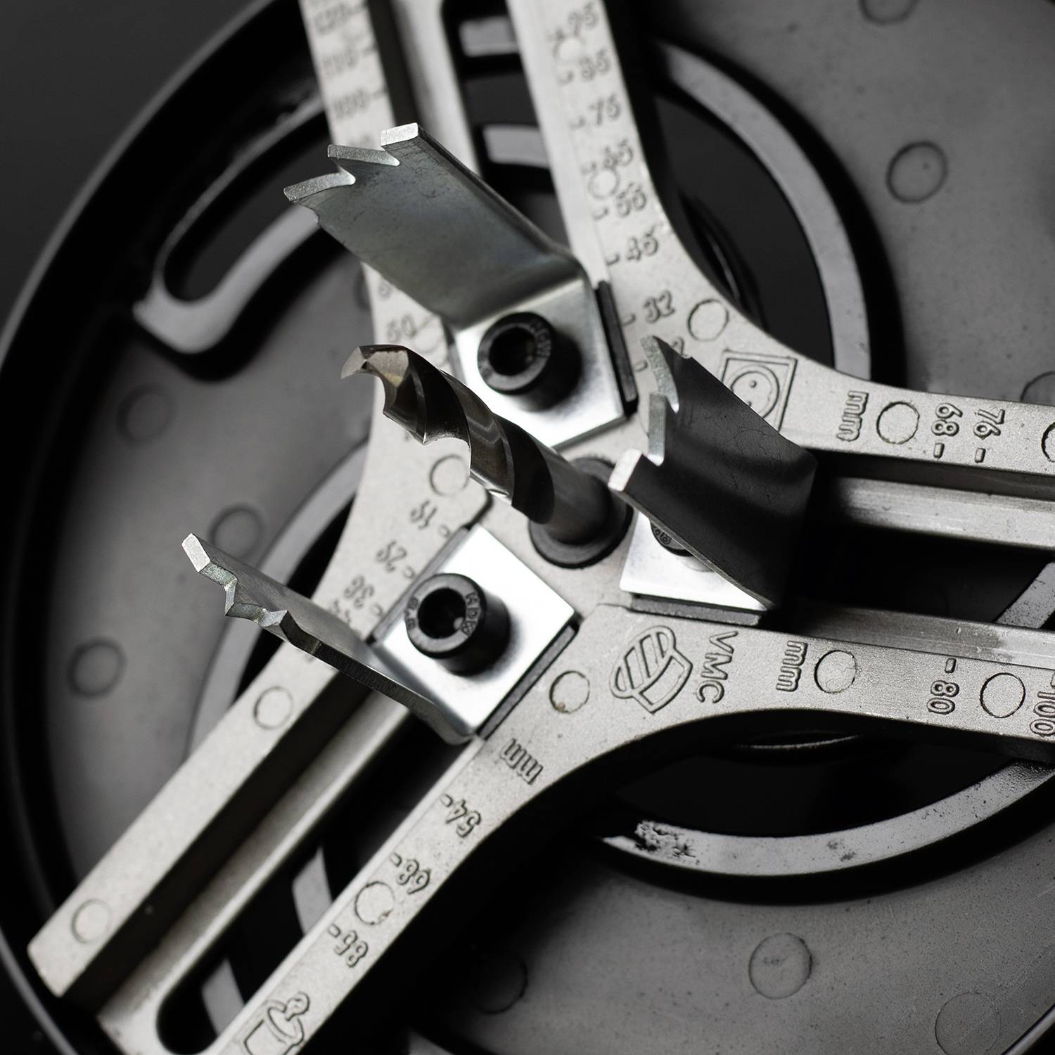 Nahaufnahme eines mechanischen Geräts mit scharfen Metallklingen, das auf einem dunklen Hintergrund liegt.