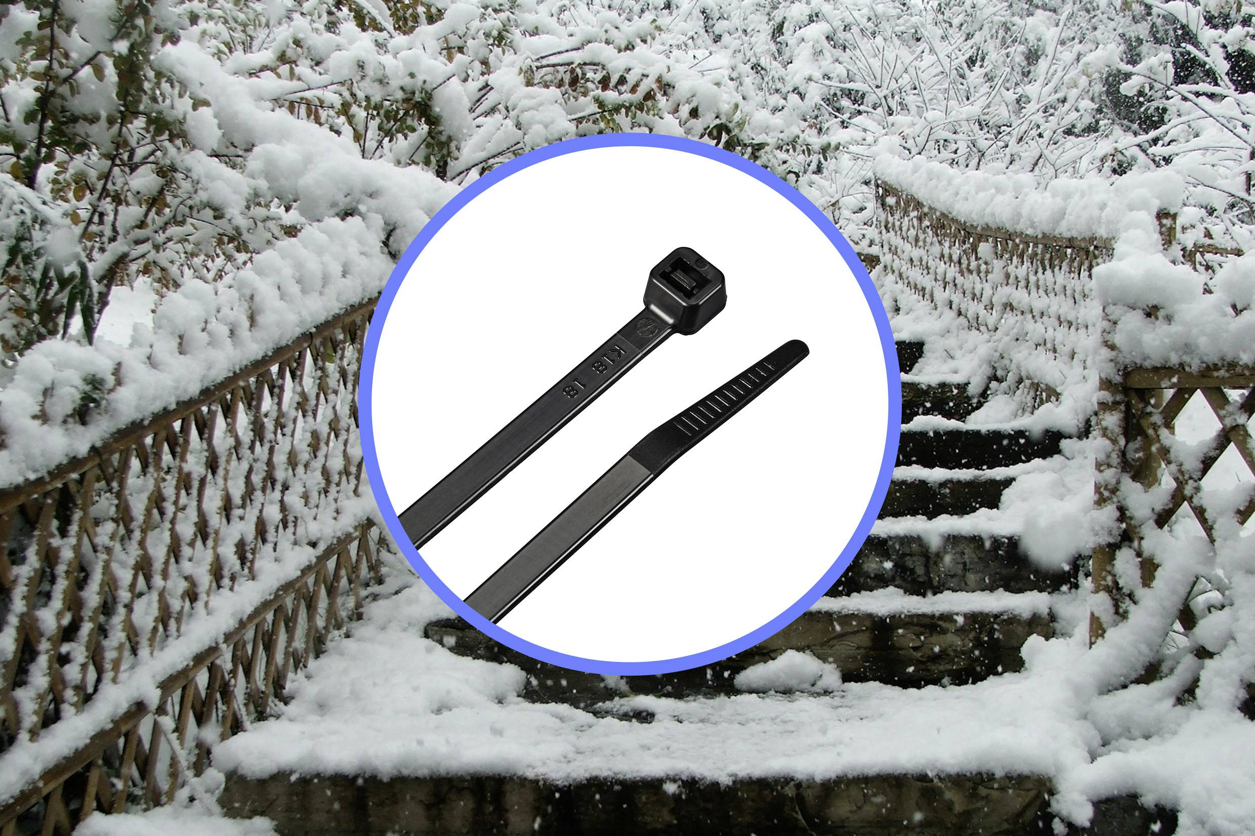 Eine schneebedeckte Treppe im Freien. Im Vordergrund ist ein schwarzer Kabelbinder abgebildet.