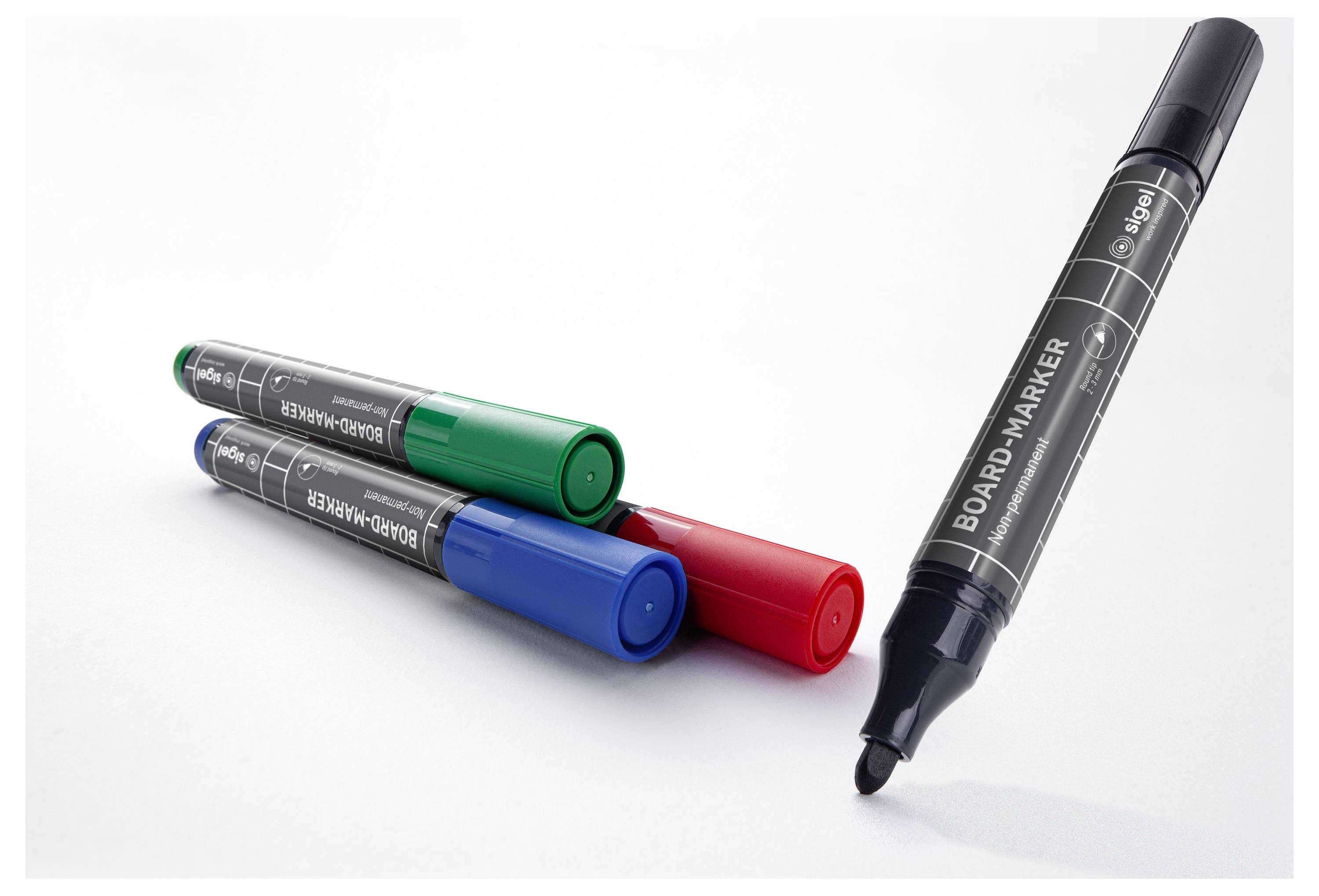 Vier Whiteboard-Marker auf weißem Hintergrund: grüne, blaue und rote Marker liegen flach, während ein schwarzer Marker aufrecht steht.