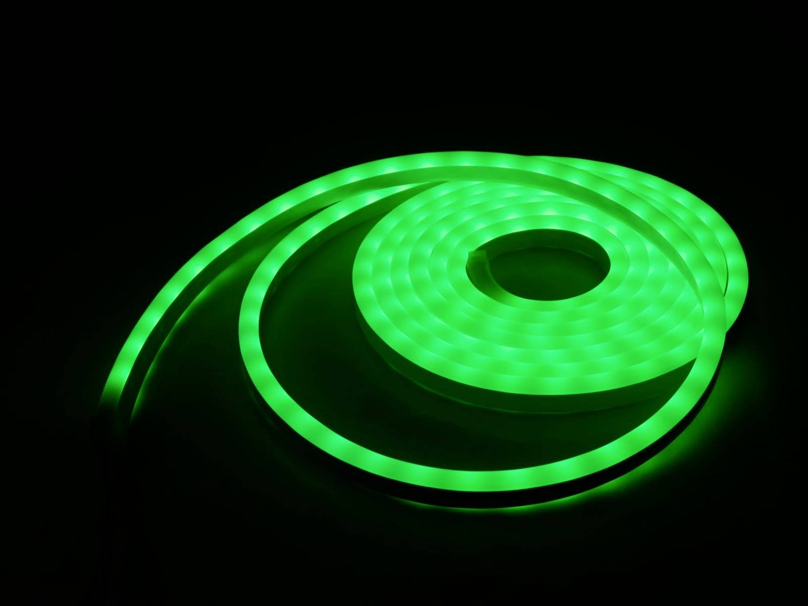Leuchtendes, grünes LED-Lichtband, spiralförmig abgewickelt, vor einem schwarzen Hintergrund.