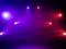 Bühne mit lila und roten Scheinwerfern beleuchtet, in einer dunklen Umgebung. Keine weiteren Objekte oder Personen sichtbar.