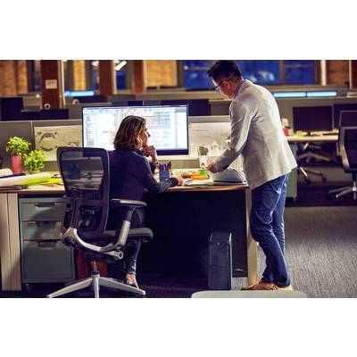 Ein Mann und eine Frau arbeiten an einem Computer in einem modernen Büro. Sie diskutieren etwas auf dem Bildschirm.