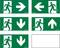 Fünf grüne Notausgangsschilder zeigen eine rennende Person mit Pfeilen nach rechts, links, oben und unten, die den Fluchtweg weisen.