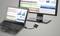 'Laptop und Monitor zeigen Tabellen und Diagramme mit Datenanalysen. Der Laptop ist über ein Kabel mit dem Monitor verbunden.'