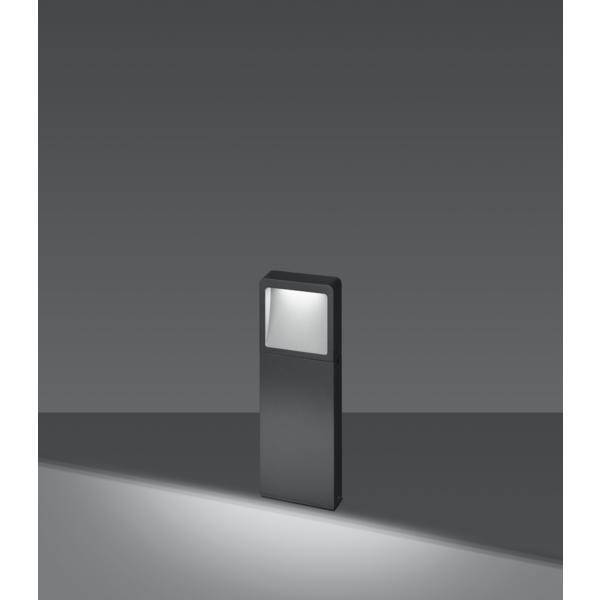 Eine moderne, rechteckige schwarze Außenleuchte strahlt sanftes Licht nach unten auf einen grauen Boden und unterstreicht ihr minimalistisches Design.