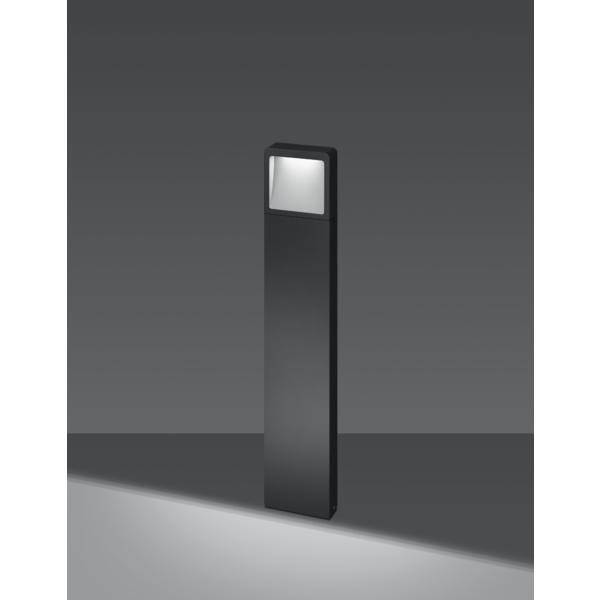 Eine moderne, schwarze Außenleuchte mit rechteckigem Kopf strahlt Licht auf den Boden und erzeugt ein sanftes, gleichmäßiges Leuchten.