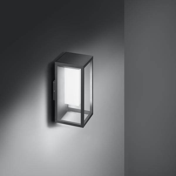 Eine moderne Wandlampe beleuchtet eine graue Wand. Die rechteckige Lampe hat ein minimalistisches Design und strahlt helles Licht aus.
