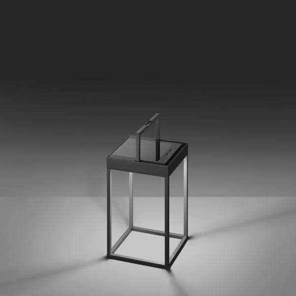 Ein minimalistisches, modernes Tischdesign in Grau mit einer rechten Winkelstruktur und einer oberen Glasplatte unter gedämpftem Licht.