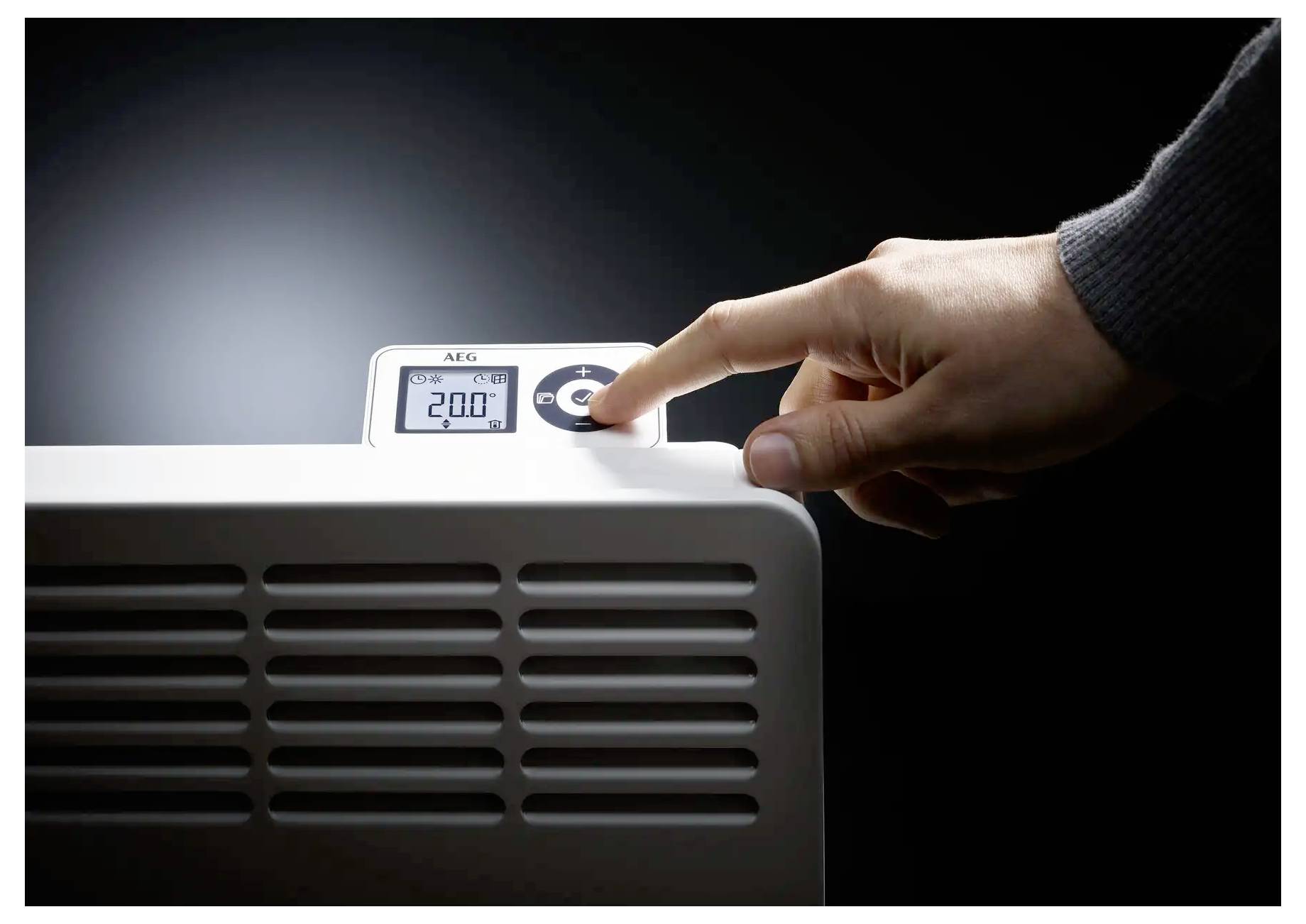 Eine Hand stellt die Temperatur auf einer digitalen Heizeranzeige ein, die „20,0°C" anzeigt. Die Bedienblende und die Hand sind der Hauptfokus.