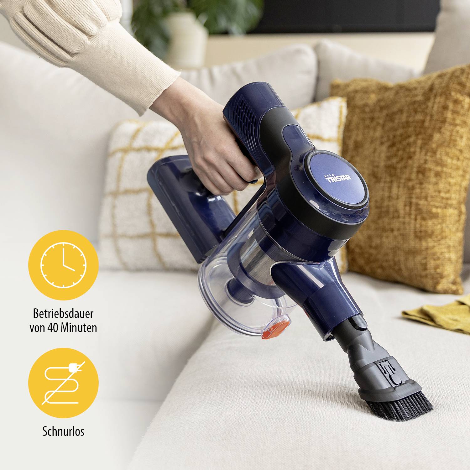 Eine Person reinigt ein Sofa mit einem kabellosen Handstaubsauger. Auf dem Bild werden Symbole für '45 Minuten Betriebsdauer' und 'Schnurlos' angezeigt.