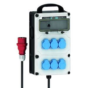 Ein tragbarer Stromverteiler mit mehreren blauen Steckdosen, einem roten Stecker und einem schwarzen Griff für einfache Handhabung.